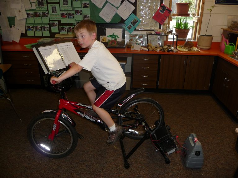 A boy uses a stationary bike to generate power