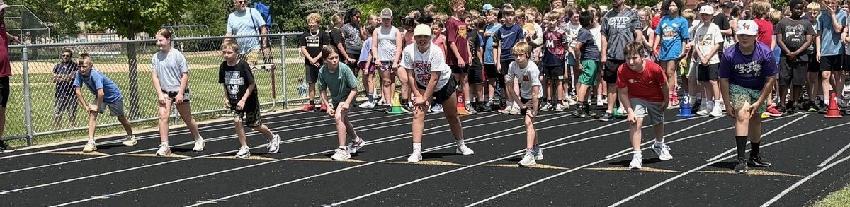 Students line up to run a race around the track at the middle school.