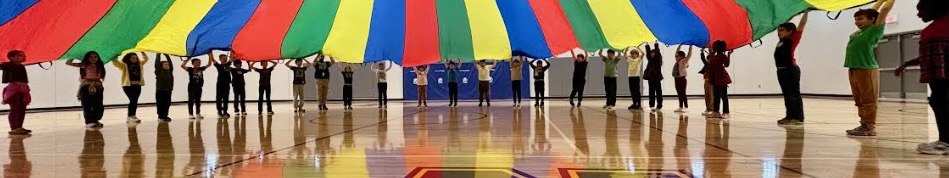 Elementary students hold the edges of a parachute.
