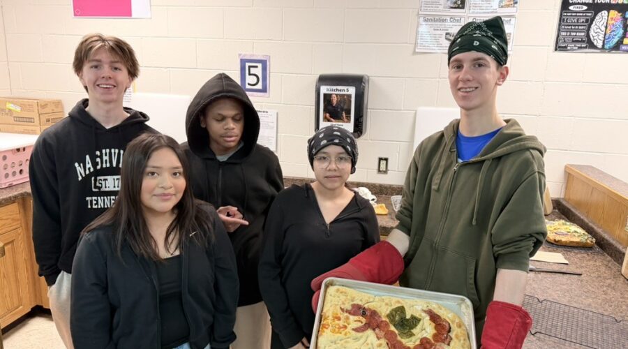 Five high school culinary students hold a pan with the item they made.