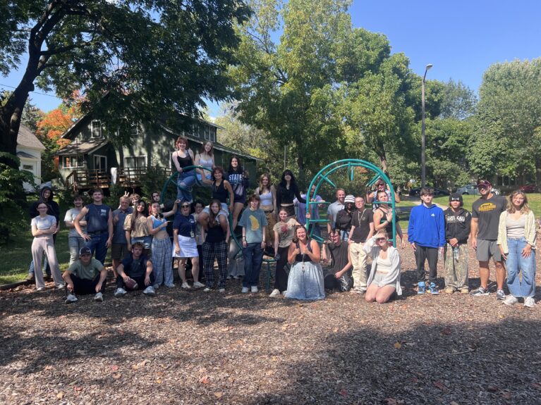 A group photo of students at the Area Learning Center, taken on a playground.