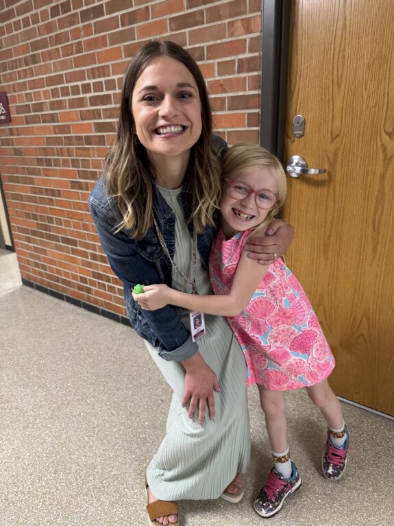 A student gives a teacher a hug.
