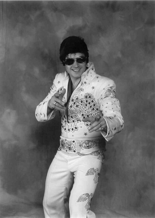 A man pretending that he's Elvis, despite the fact that he is not Elvis