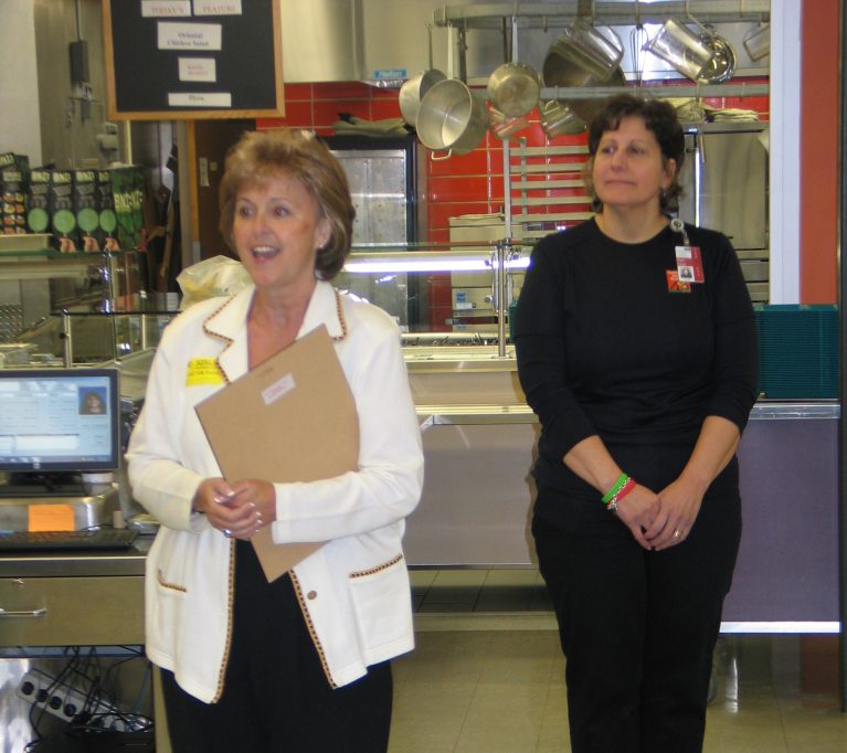 Two women stand while receiving an award