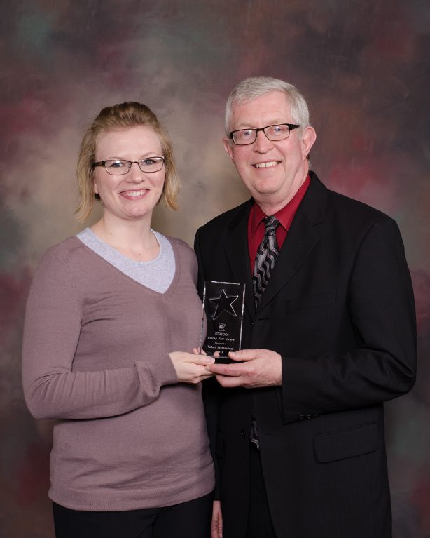 A woman recieves the Masbo Risingstar Award from a man in a suit.